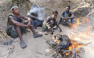 Young Hadzabe men roasting an antelope for food